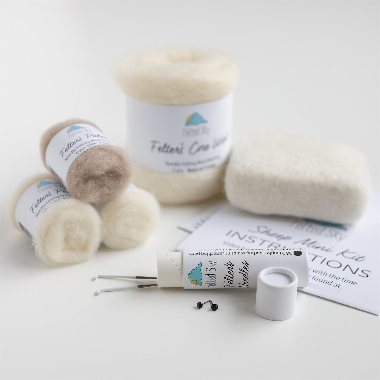 Detailed view of included supplies for the white sheep needle felting kit.