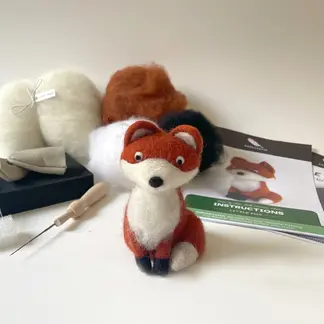 Needle felting fox kit with completed orange and white felted fox figurine, wool roving, needles and instructions